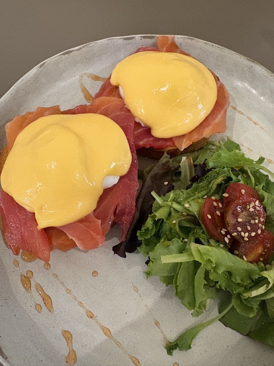 Huevos Benedict con salsa holandesa sobre salmón y muffins ingleses, ensalada de verduras mixtas